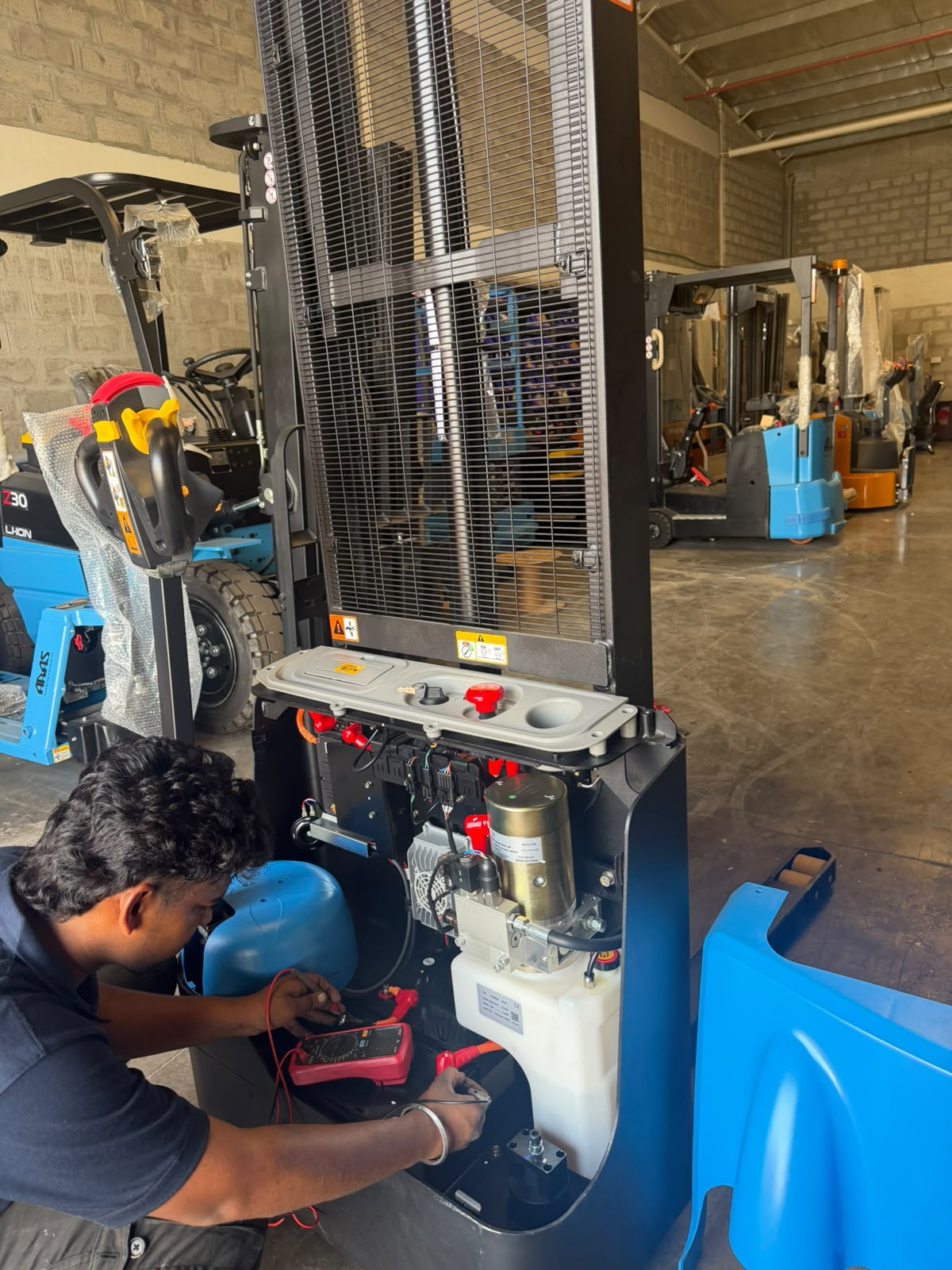 ARAS engineer testing the control circuit of an electric pallet stacker at the ARAS workshop in JAFZA, Dubai